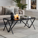 black glass coffee table with geometric legs in room